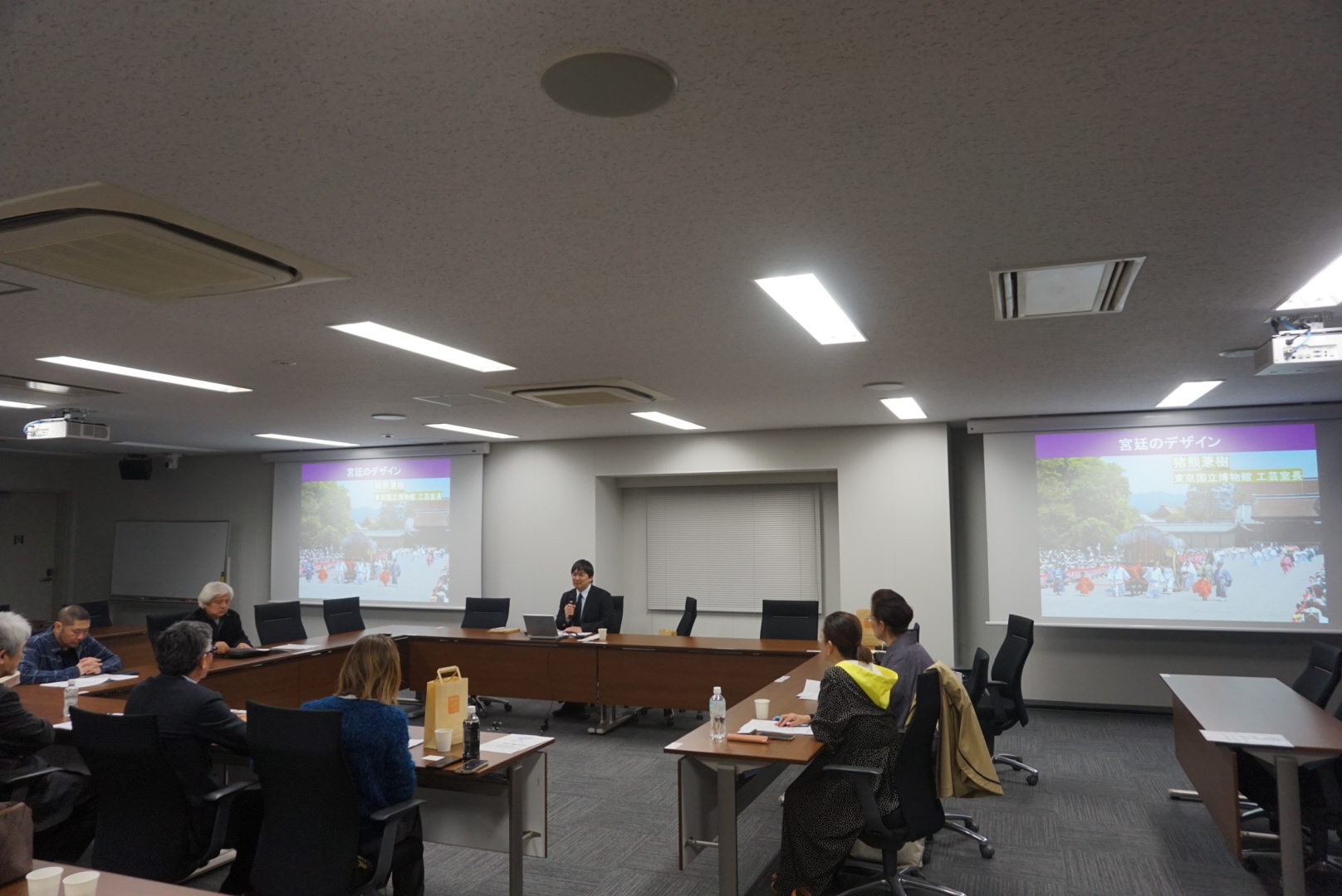 会場の全景。スクリーンに宮廷儀礼の構造図が映り、参加者が着席している様子